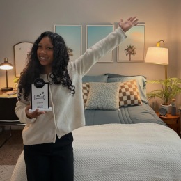 a person holding a sign in front of a bed